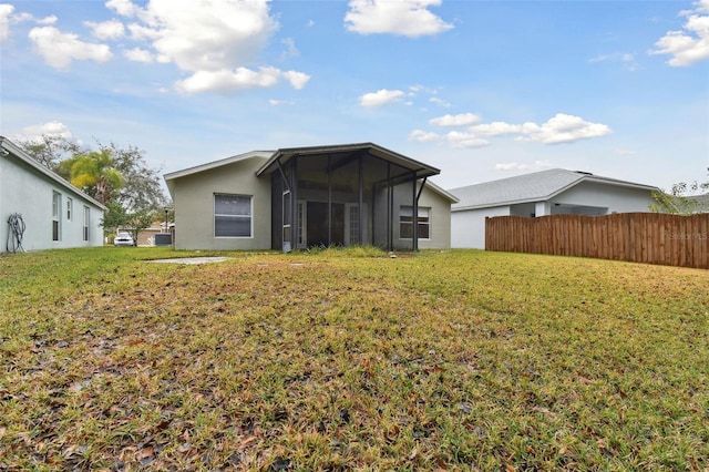 back of house with a sunroom and a yard