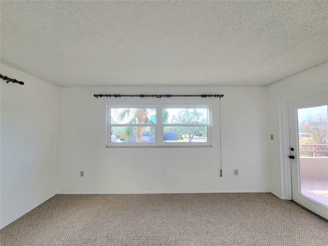 carpeted empty room with a textured ceiling