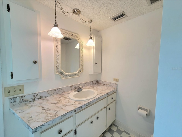 bathroom with a textured ceiling and vanity