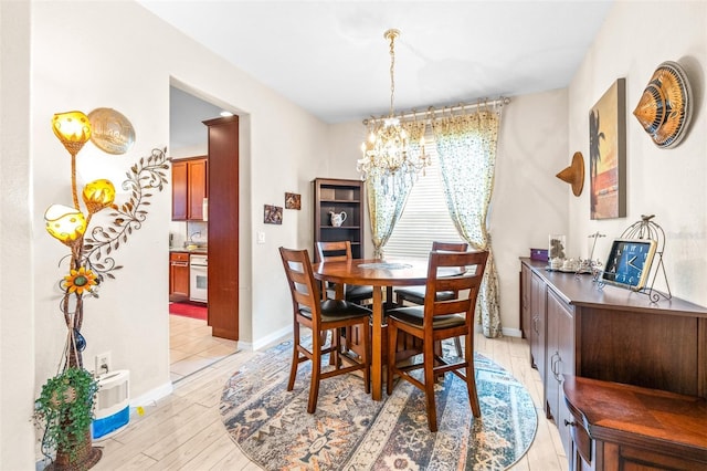 dining room with light hardwood / wood-style flooring and a notable chandelier