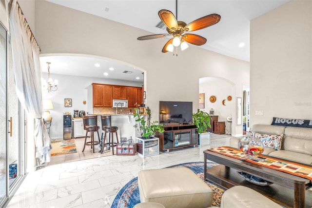 living room with ceiling fan with notable chandelier