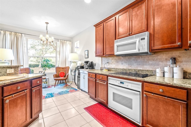 kitchen featuring pendant lighting, decorative backsplash, an inviting chandelier, white appliances, and light tile patterned floors