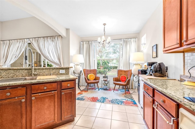 kitchen with decorative light fixtures, light tile patterned flooring, a chandelier, light stone counters, and sink