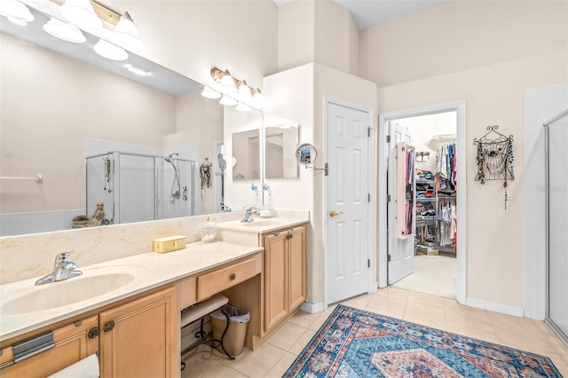 bathroom with a shower with shower door, tile patterned floors, and vanity