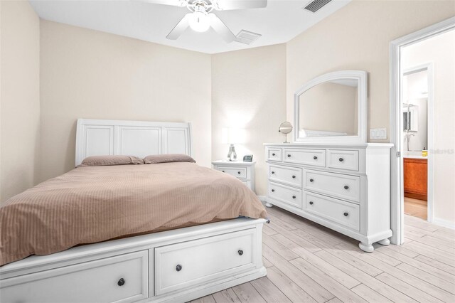 bedroom featuring light wood-type flooring, ceiling fan, and ensuite bath