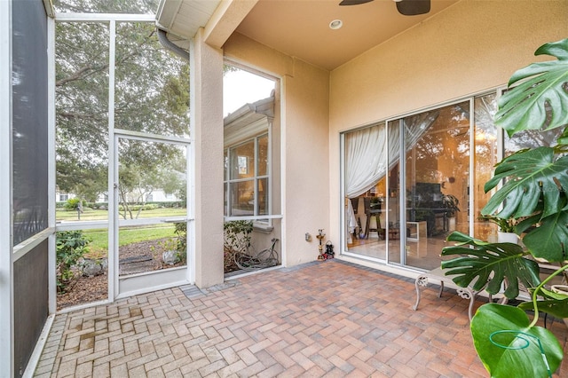 unfurnished sunroom featuring ceiling fan