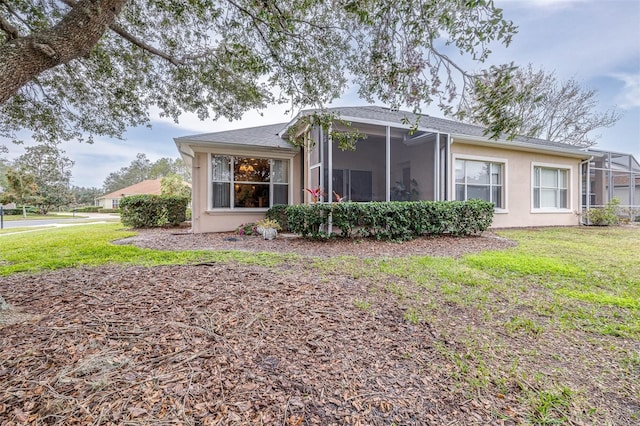 back of house featuring a sunroom and a yard