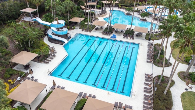 view of swimming pool with a water slide and a patio