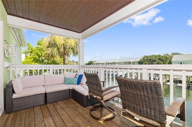 wooden terrace featuring a water view and outdoor lounge area