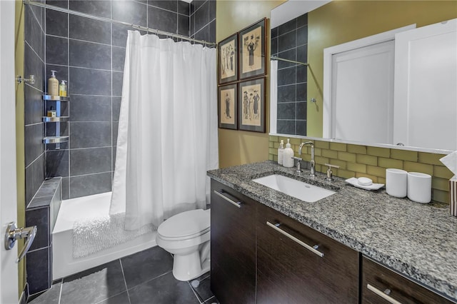 full bathroom with tile patterned flooring, vanity, shower / tub combo, tasteful backsplash, and toilet