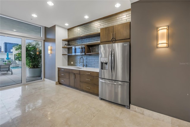 kitchen with sink, backsplash, and stainless steel fridge with ice dispenser