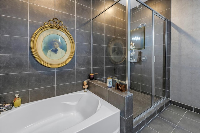 bathroom featuring tile patterned flooring, tile walls, and separate shower and tub