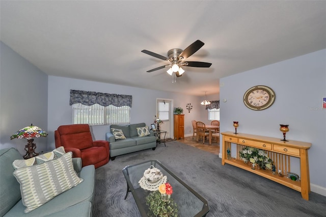 living room with ceiling fan with notable chandelier and carpet