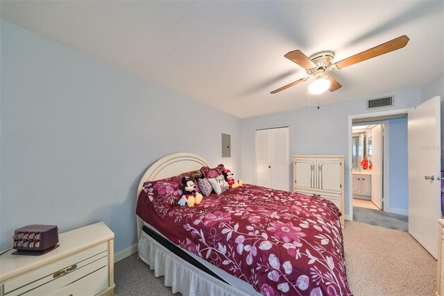 carpeted bedroom with electric panel, ceiling fan, and a closet