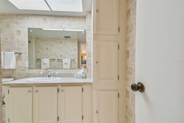 bathroom featuring a skylight and vanity