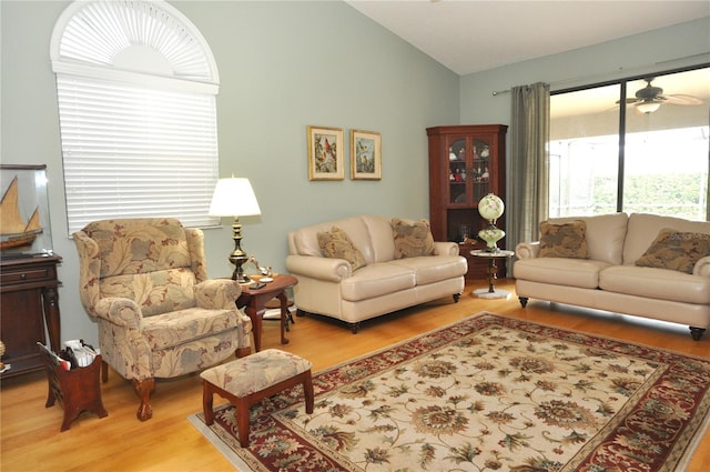 living room featuring ceiling fan, wood-type flooring, and lofted ceiling