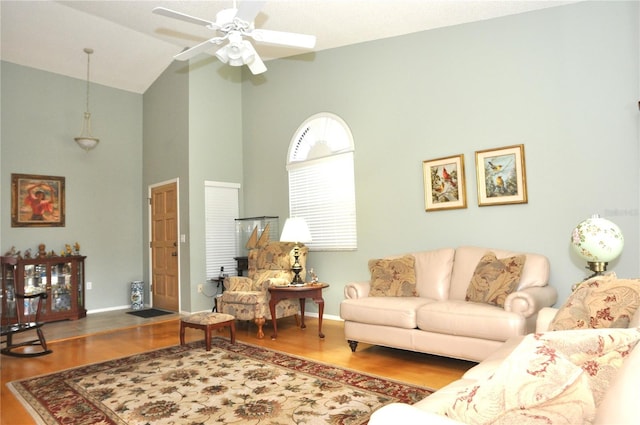 living room featuring hardwood / wood-style flooring, ceiling fan, and vaulted ceiling