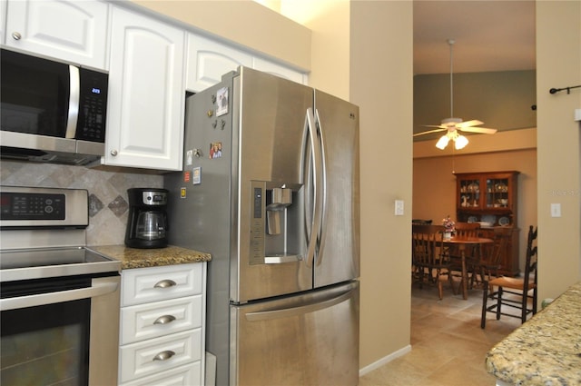 kitchen featuring backsplash, white cabinets, stone countertops, and stainless steel appliances