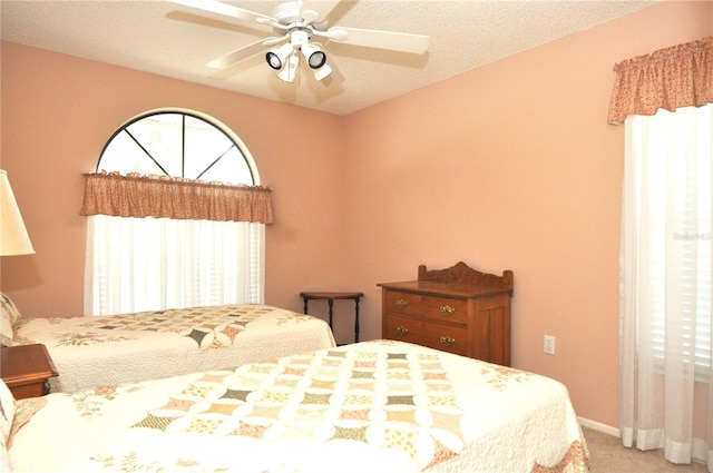 bedroom with ceiling fan, a textured ceiling, and carpet floors