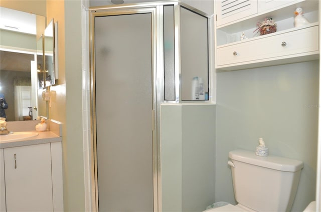 bathroom with toilet, a shower with shower door, and vanity