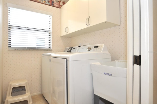 washroom with cabinets, sink, and washer and clothes dryer