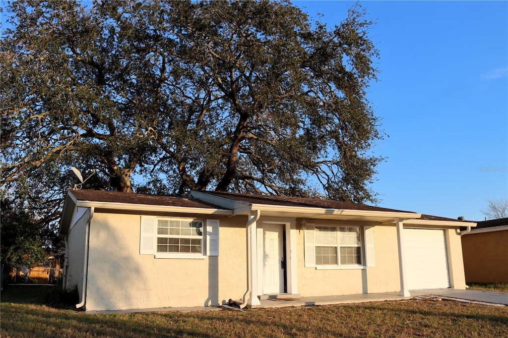 single story home featuring a front yard and a garage