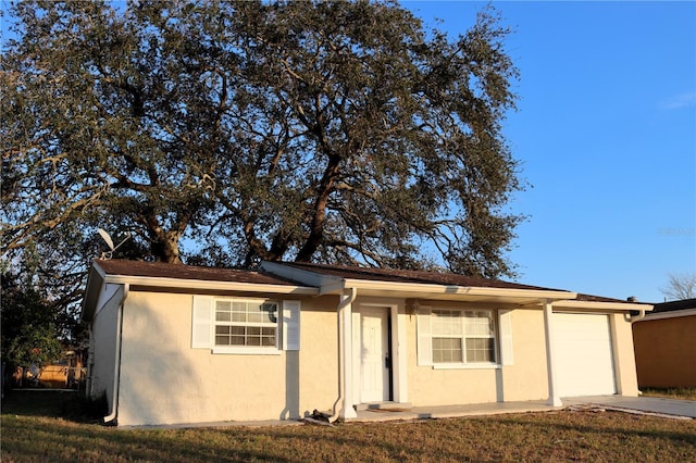 single story home featuring a front yard and a garage