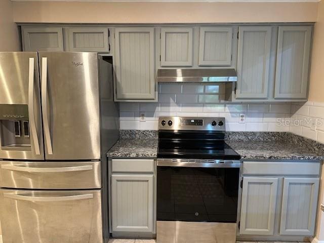 kitchen with dark stone counters, appliances with stainless steel finishes, gray cabinets, and tasteful backsplash