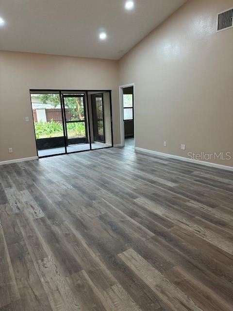 unfurnished room with high vaulted ceiling and dark hardwood / wood-style floors