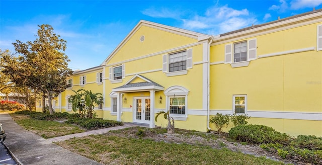 townhome / multi-family property with french doors and stucco siding