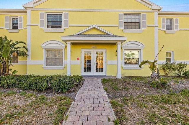 entrance to property featuring french doors and stucco siding