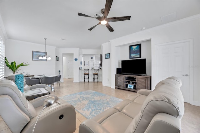 living room with light tile patterned floors, ceiling fan with notable chandelier, and ornamental molding