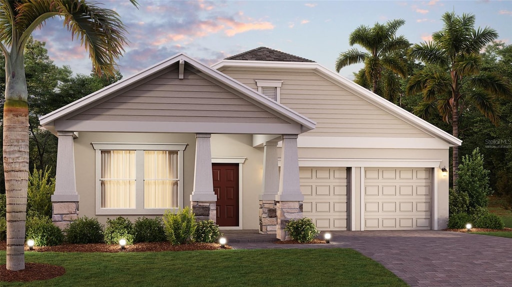 view of front facade with a yard and a garage