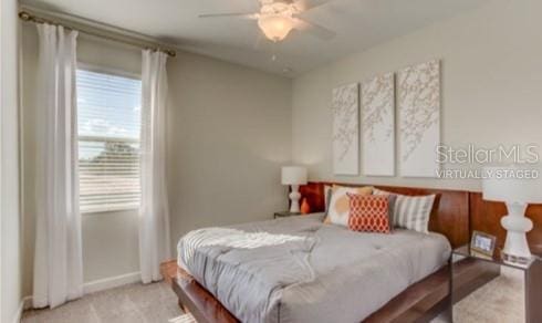 bedroom with ceiling fan and light carpet