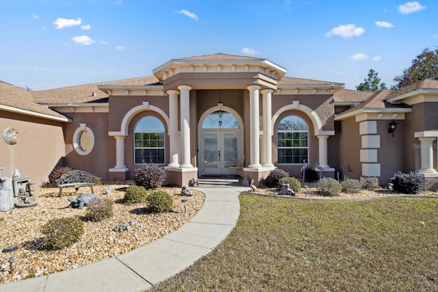 view of front of property featuring a front yard and french doors