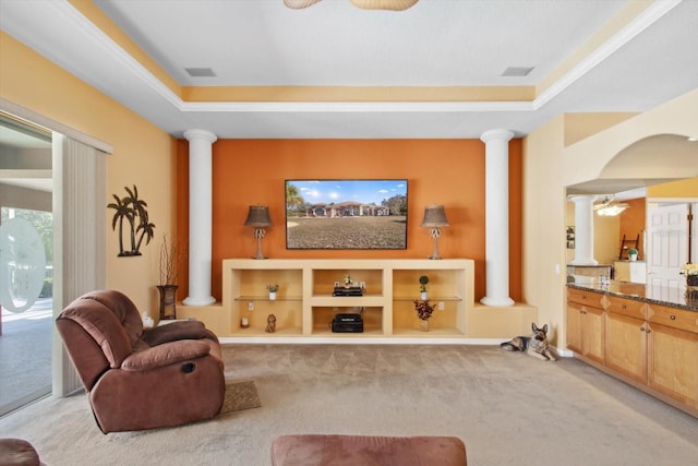 living room with a raised ceiling, ceiling fan, light carpet, and ornate columns