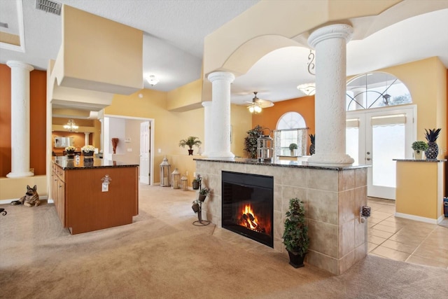 welcome area with a tiled fireplace, ceiling fan, and french doors