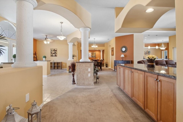 interior space with light carpet, a chandelier, and ornate columns