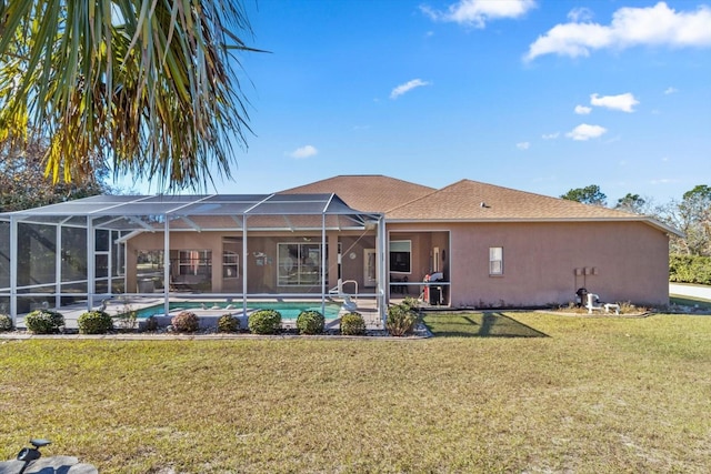 back of property with glass enclosure and a lawn