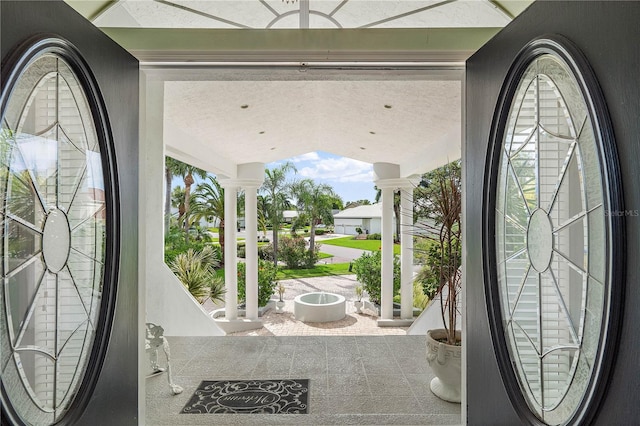 entrance foyer featuring decorative columns and a textured ceiling