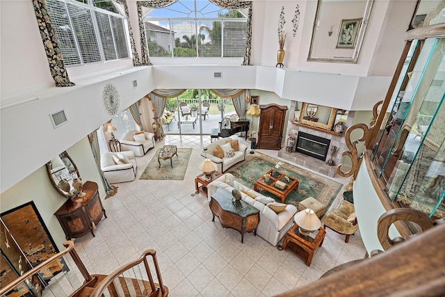 living room featuring a high ceiling, light tile patterned floors, and a high end fireplace