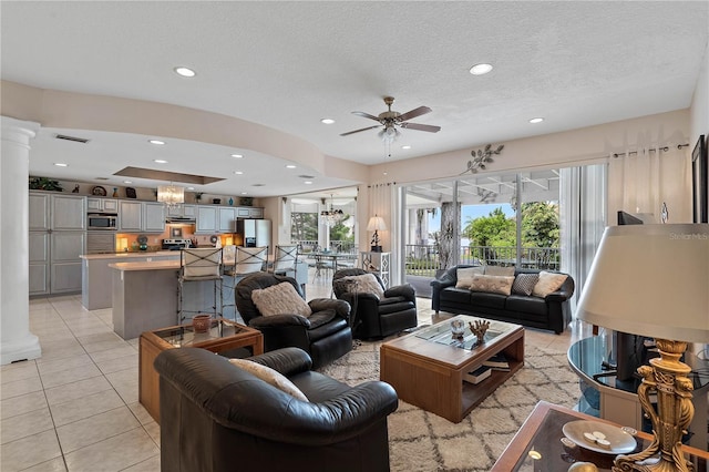 living room featuring decorative columns, a wealth of natural light, and light tile patterned flooring