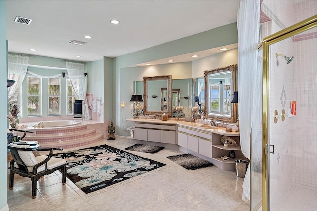 bathroom with tile patterned flooring, vanity, and shower with separate bathtub