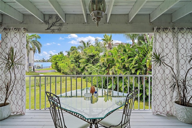 wooden terrace with a lawn and a water view