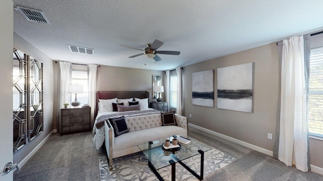 carpeted bedroom with ceiling fan and a textured ceiling