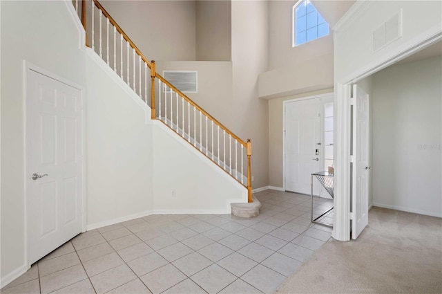 tiled foyer entrance featuring a towering ceiling