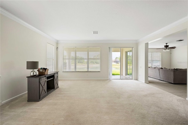 unfurnished living room with ceiling fan, ornamental molding, and light carpet