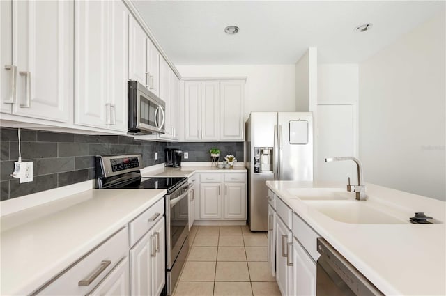 kitchen with white cabinets, appliances with stainless steel finishes, sink, and light tile patterned floors