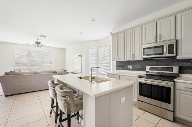 kitchen featuring a wealth of natural light, sink, a kitchen island with sink, light tile patterned floors, and stainless steel appliances