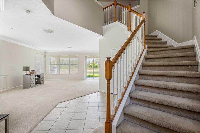 staircase featuring crown molding and carpet